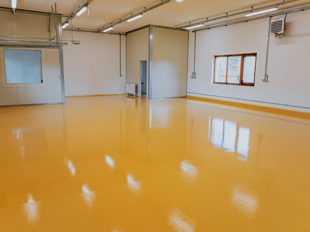 Finished commercial epoxy floor, showcasing a shiny, smooth, and durable yellow surface.